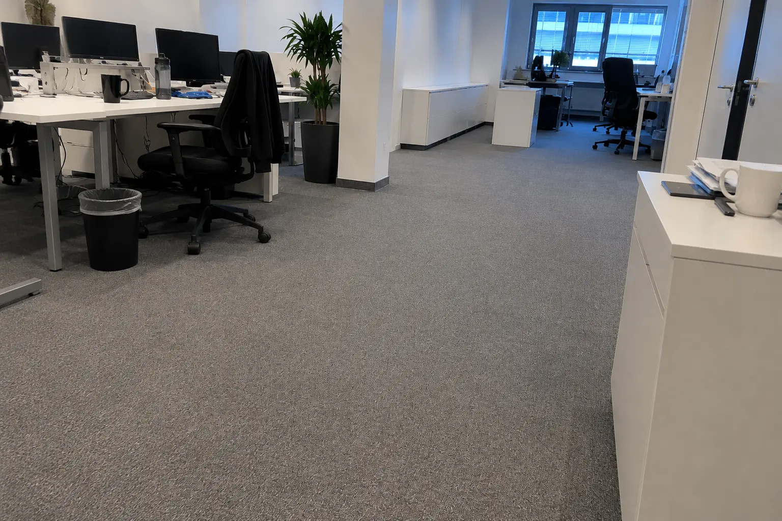 Gereinigtes Großraumbüro mit Teppichboden und Arbeitsplätzen